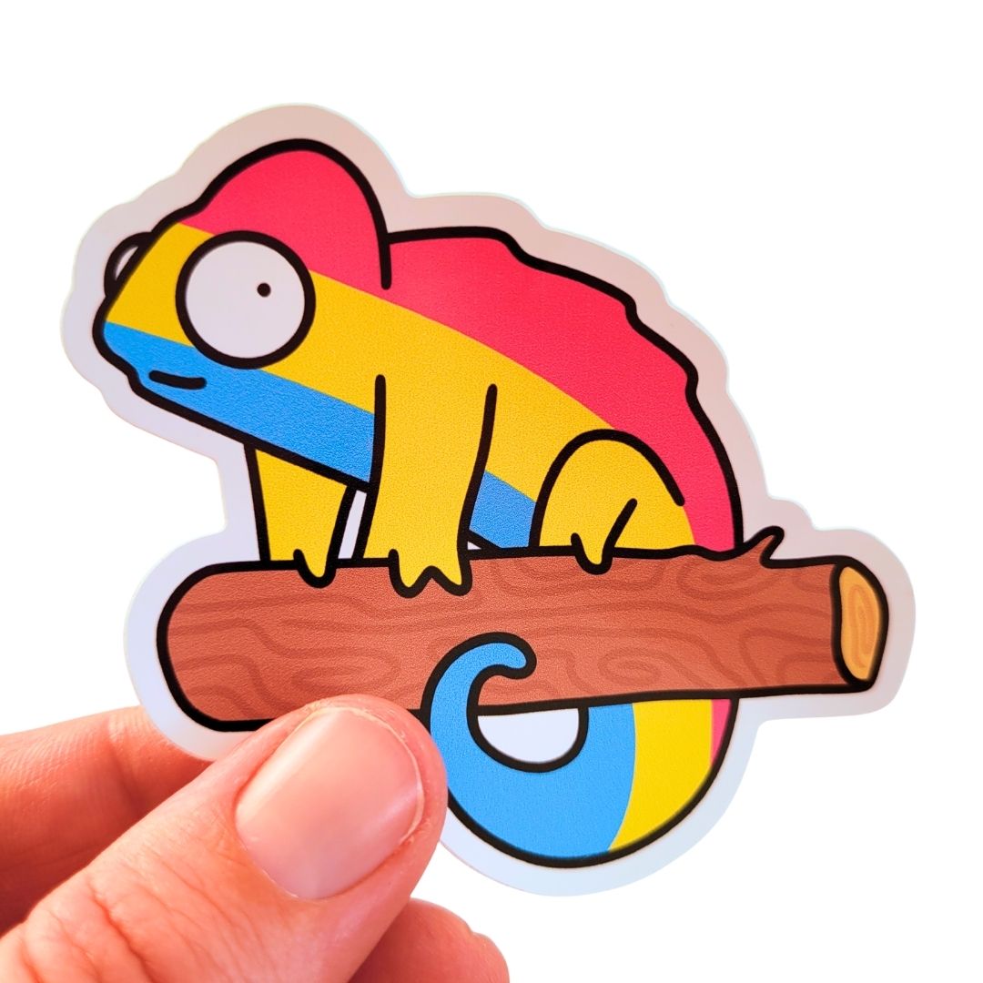 Colourful sticker of a pansexual flag chameleon on a branch held by a hand against a white background