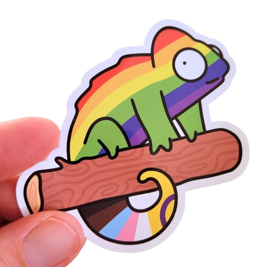 Colourful sticker of a rainbow chameleon on a branch held by a hand.