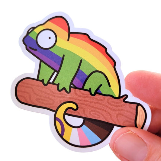 Colourful sticker of a rainbow chameleon on a branch held by a hand.