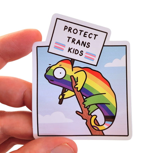 Sticker with a rainbow-coloured chameleon holding a sign that says 'Protect Trans Kids' held by a hand.