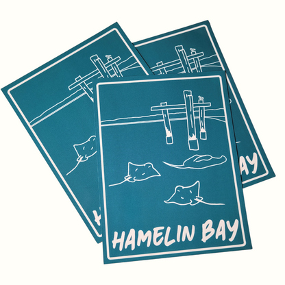A set of blue square magnets with 'HAMELIN BAY' text and line drawings of a jetty and stingrays
