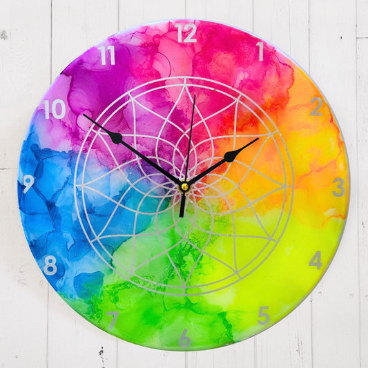 A neon coloured clock with silver detail and black hands
