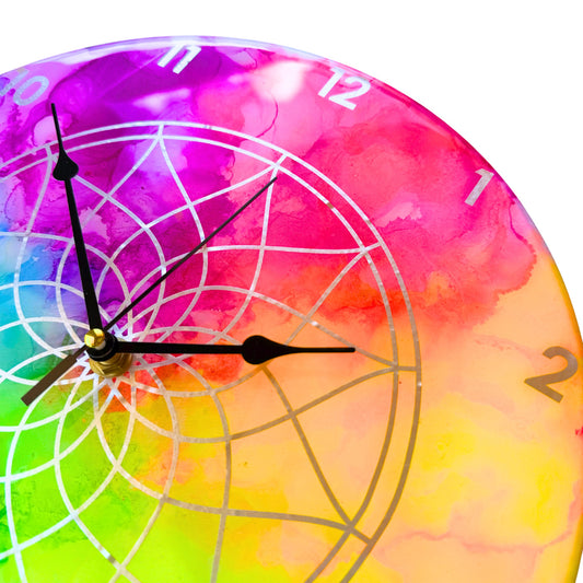 A neon coloured clock with silver detail and black hands