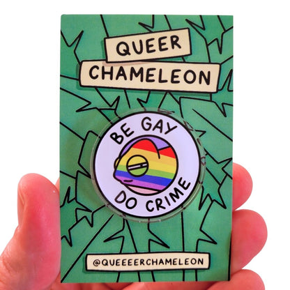 Pin with rainbow design and text on a green card with 'Queer Chameleon' branding.