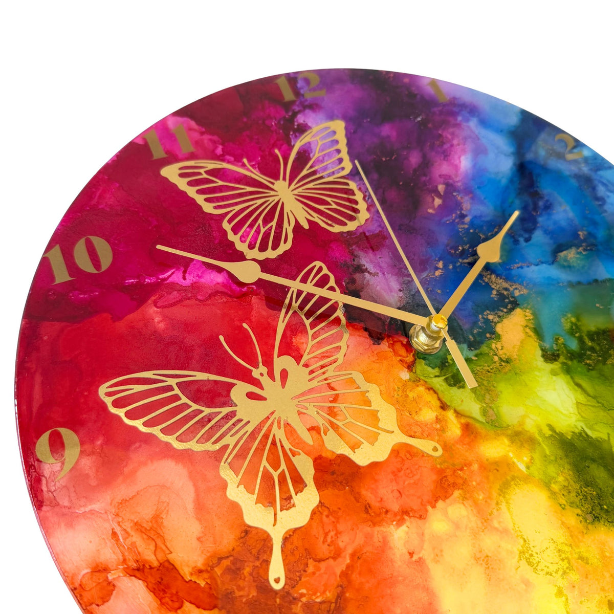 Round wall clock with a vibrant rainbow design and gold butterfly illustrations, with gold arabic numerals and gold hands.