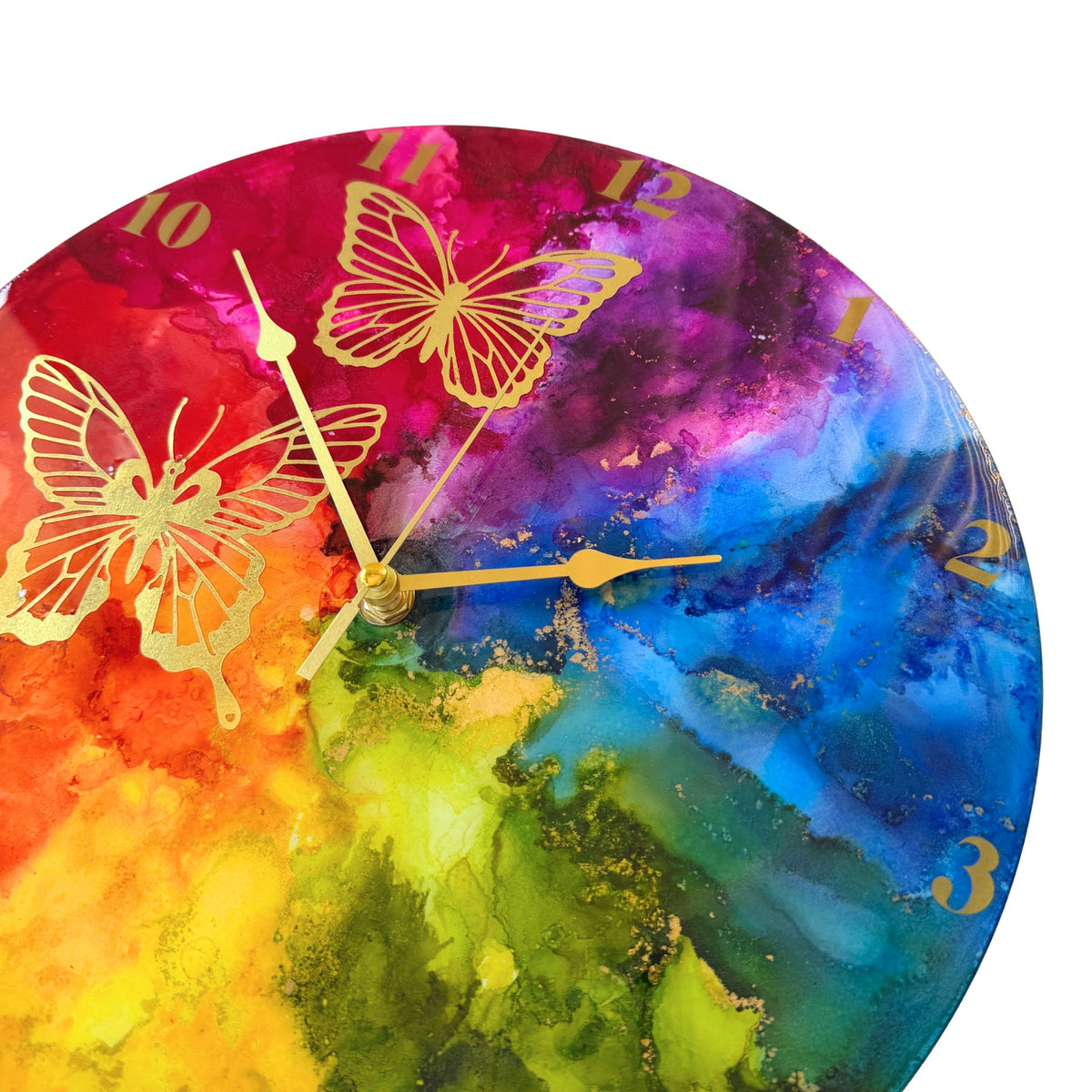 Round wall clock with a vibrant rainbow design and gold butterfly illustrations, with gold arabic numerals and gold hands.