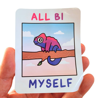 Card with a colourful chameleon illustration and text 'ALL BI MYSELF' held by a hand.
