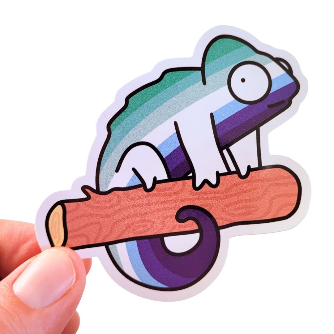 Colourful sticker of a chameleon on a branch held by a hand against a white background