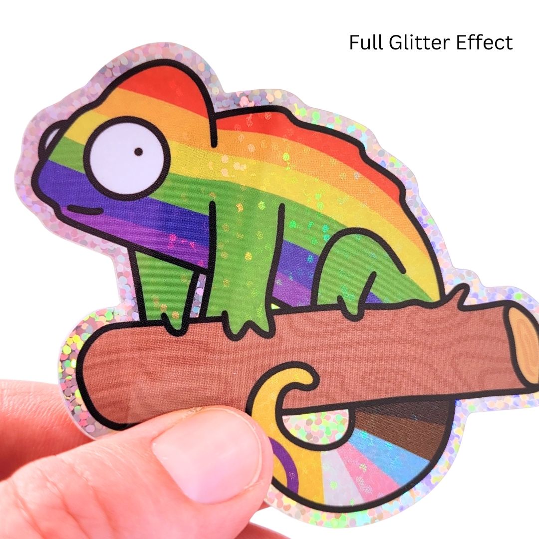 Colorful chameleon sticker with a full glitter effect held by a hand on a white background.