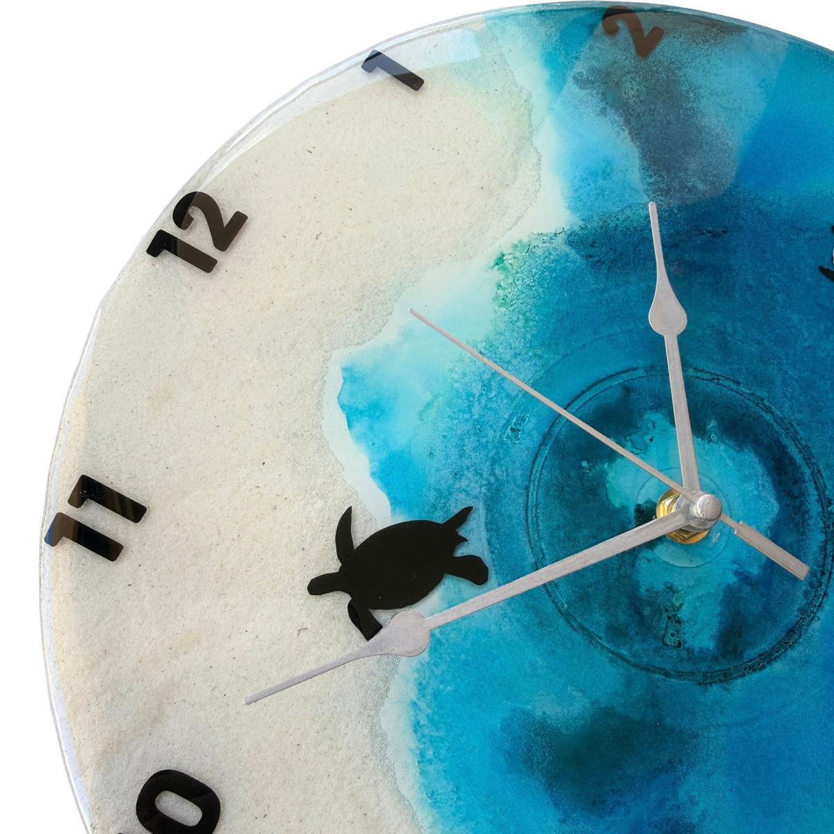 A beach coloured clock with black numbers and turtles