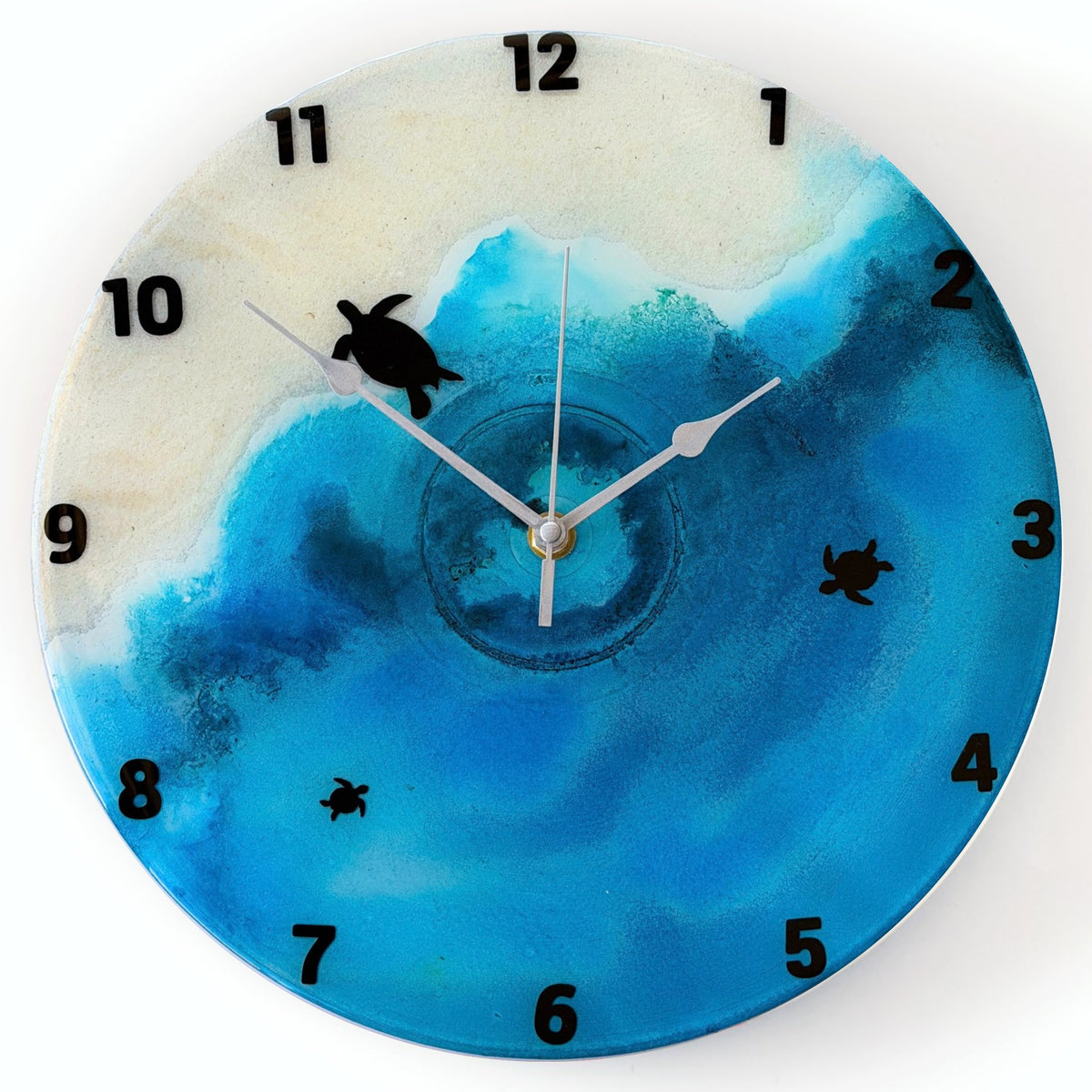 A beach coloured clock with black numbers and turtles